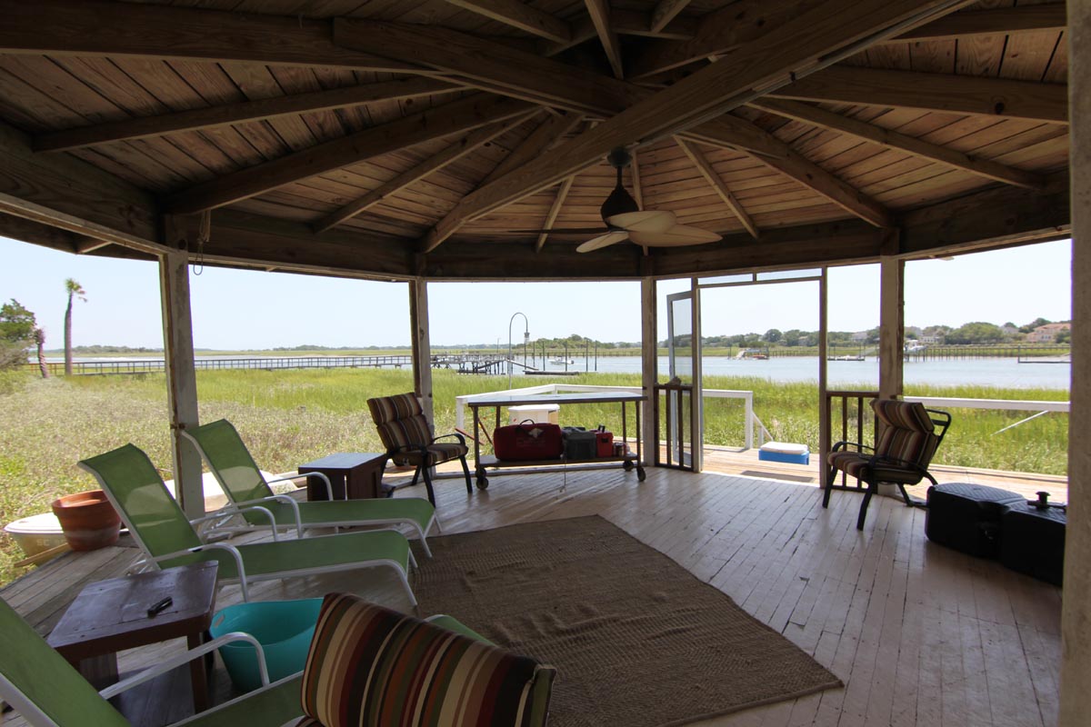 Screened waterfront gazebo with lounge seating overlooking the marsh at Goat Island Resort