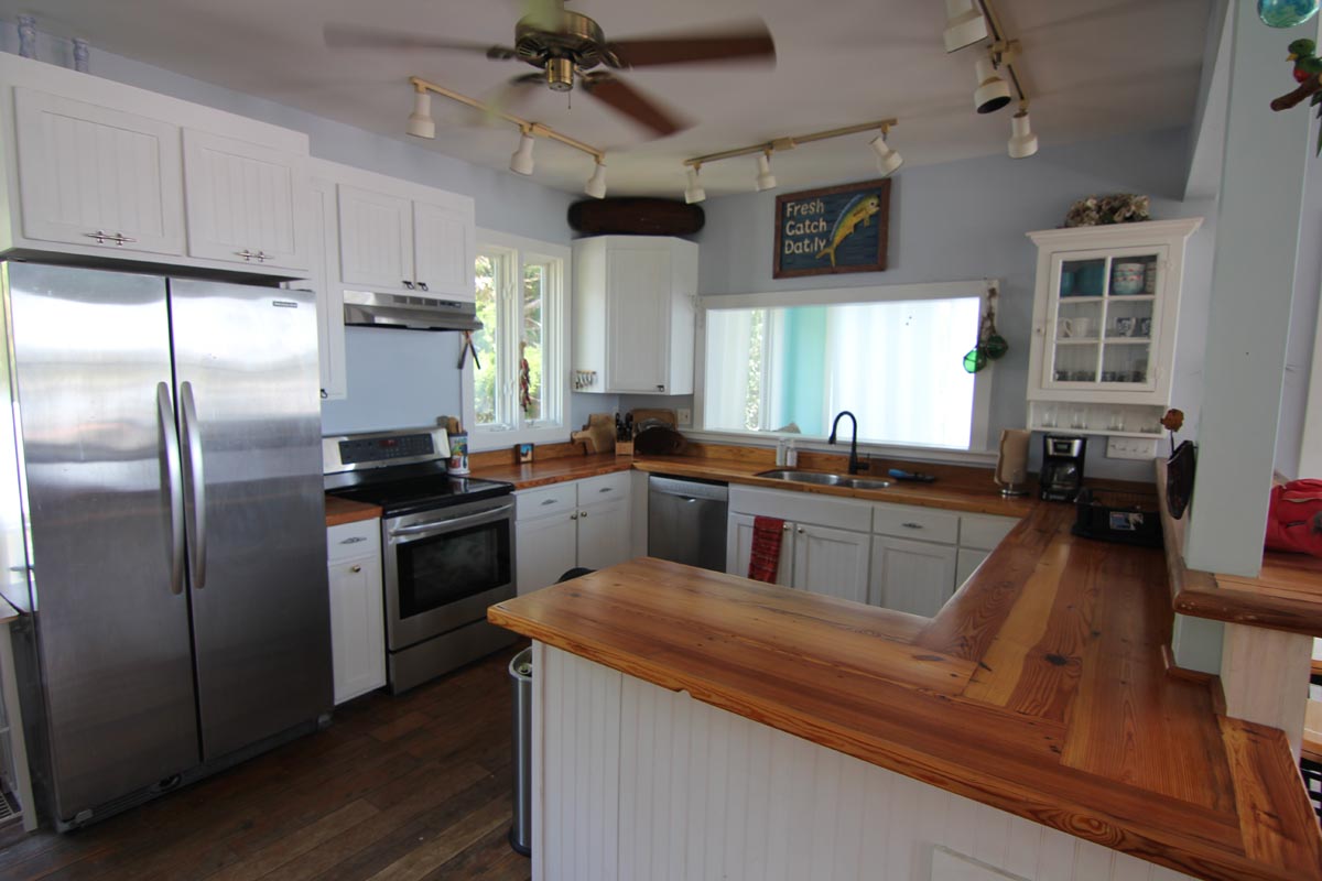 Kitchen at Goat Island Resort Rental House with heart pine countertops, stainless appliances, and raised bar