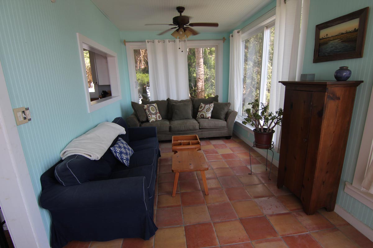 Sunroom living area with comfortable sofas and large windows at Goat Island Resort