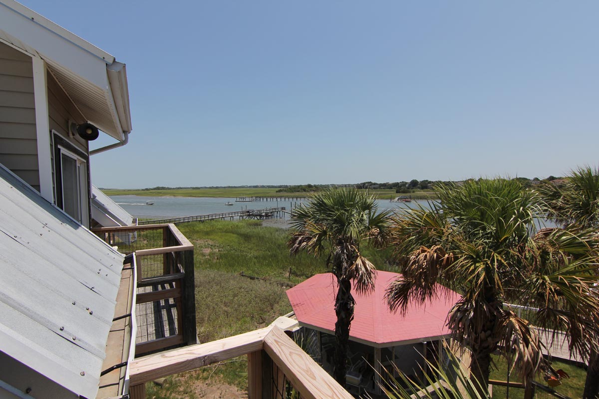 Balcony view over the gazebo, palm trees, and waterway at Goat Island Resort