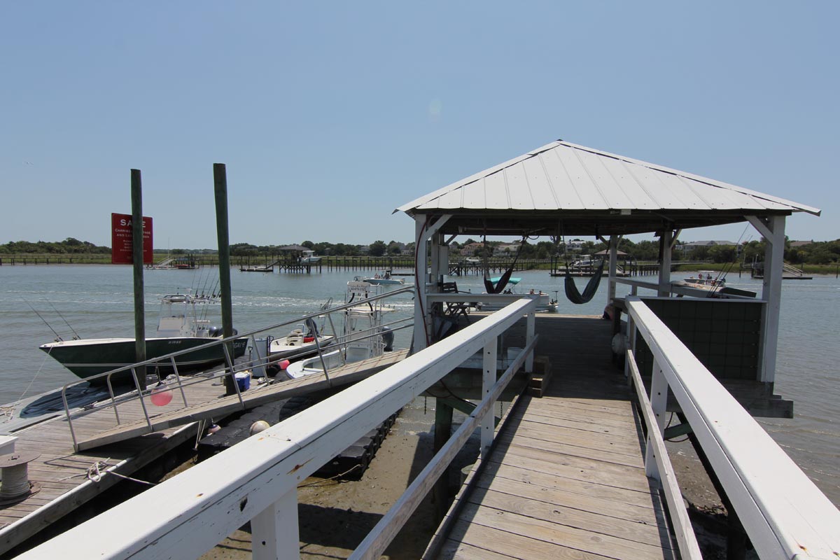 Covered boat dock at Goat Island Resort with boats tied up, a short ride from Isle of Palms Marina